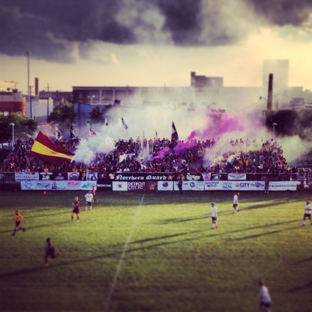Smoke rises over the Cass Tech stands as supporters celebrate a goal